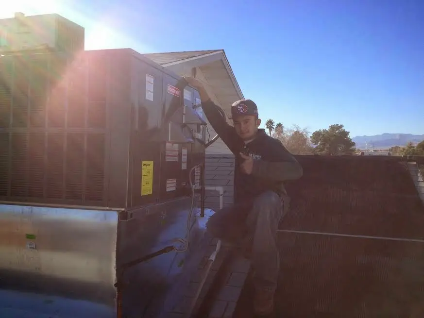 HVAC technician performing Air Duct Cleaning on a rooftop unit in Lower Saucon
